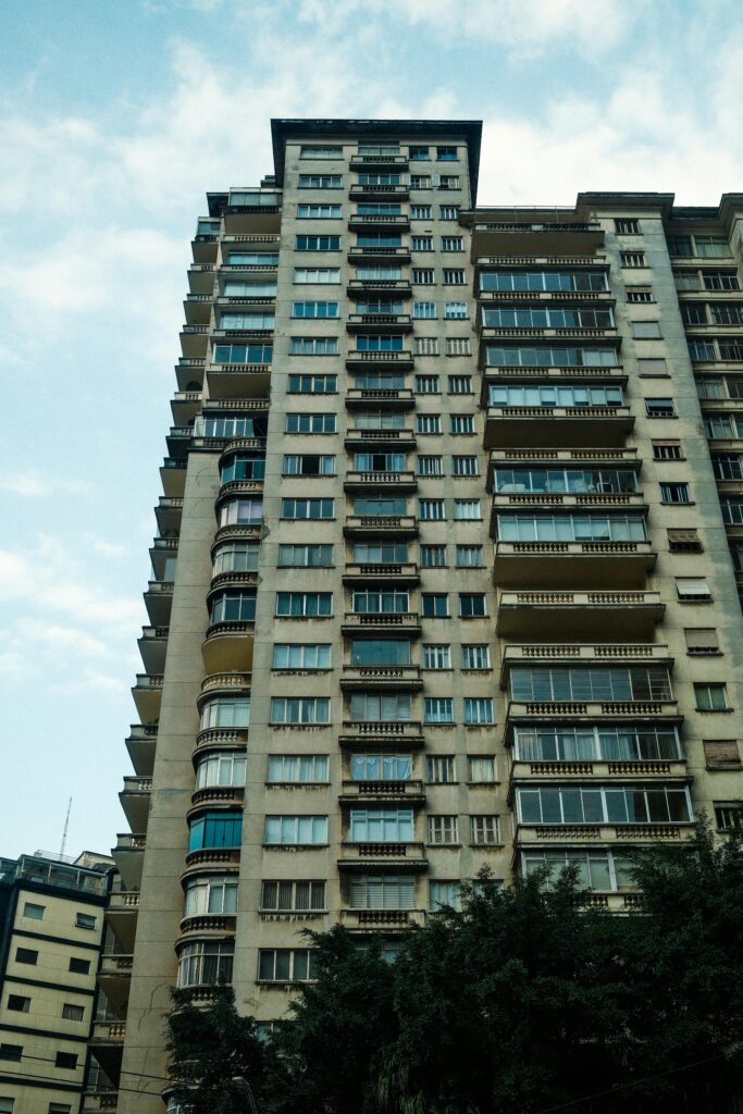 High-rise apartment building in São Paulo, showcasing urban architecture against a bright sky.
